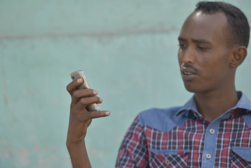 Africa, Somalia - Deeq Ahmed Shire on his phone at a street tea shop at the Jardiinka bar quatro square in downtown Mogadishu during his tea break.  The Alshabaab have banned the use of internet mobile usage on all mobile devices thereby affecting the use of 3G services which have just been rolled out by mobile service providers. He says that he can't live without internet as it connects him with his family and friends outside Somalia. AU UN IST PHOTO/ David Mutua